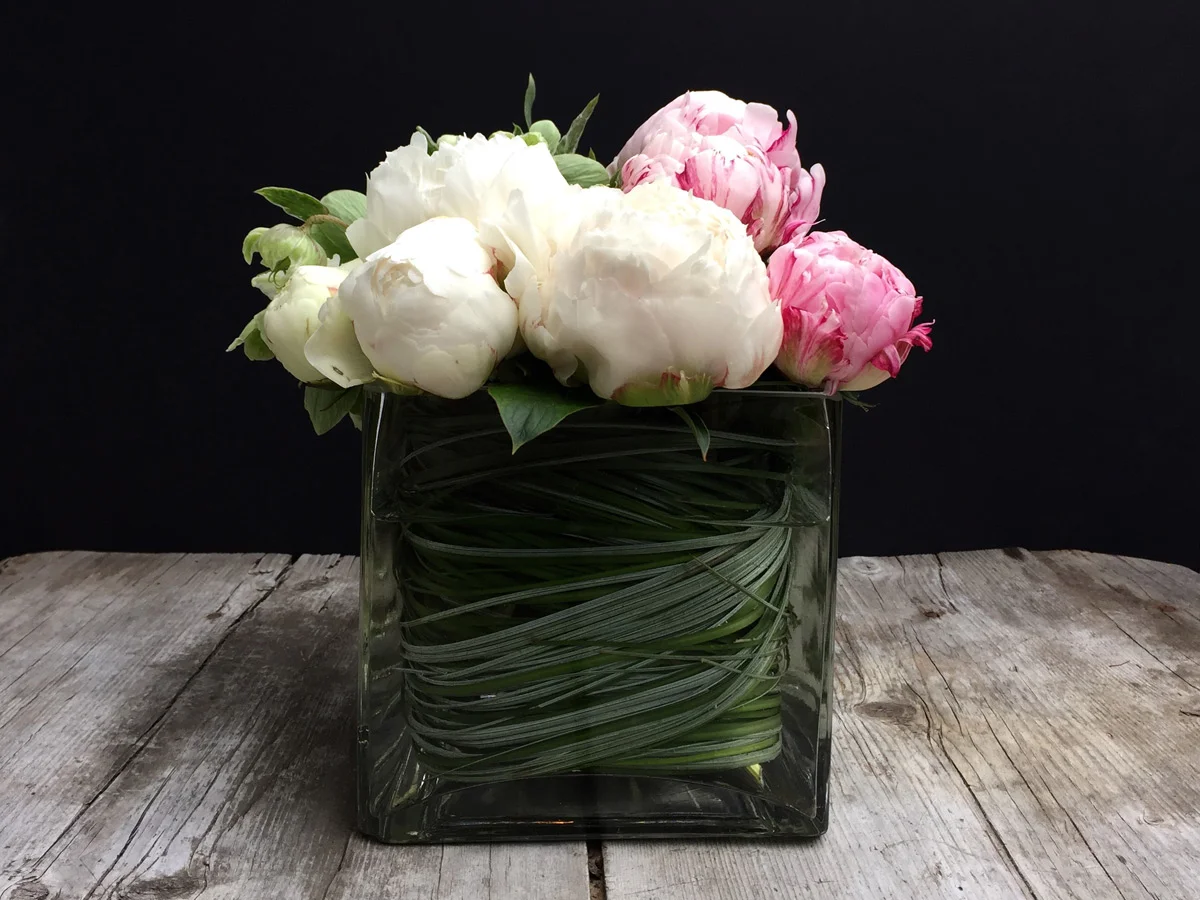 Peonies in a leaf-wrapped cube