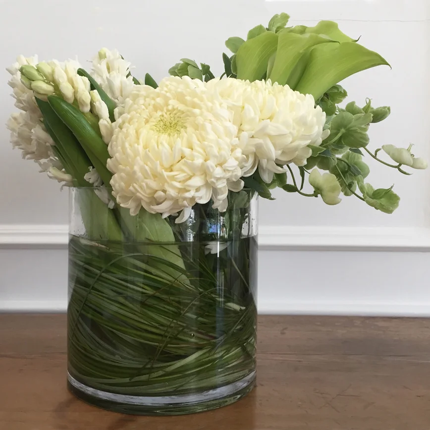 Chrysanthemum and calla in leaf-lined glass