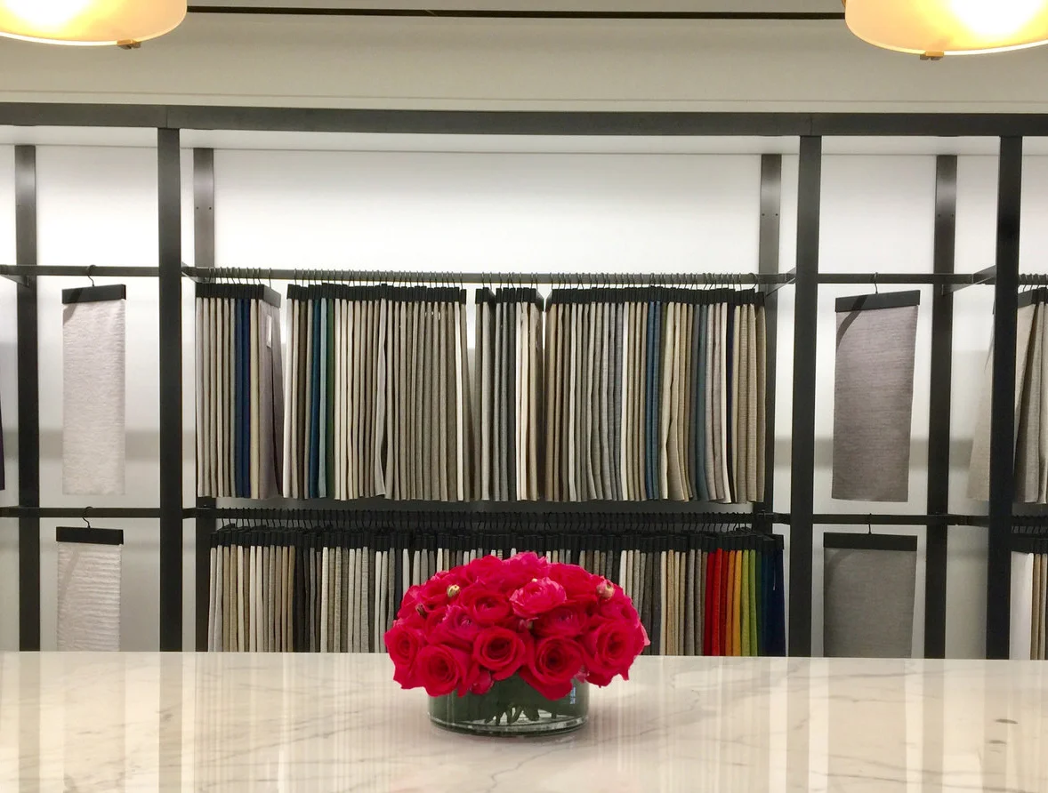 A low scarlet posy on white marble — one confident note in a neutral room.